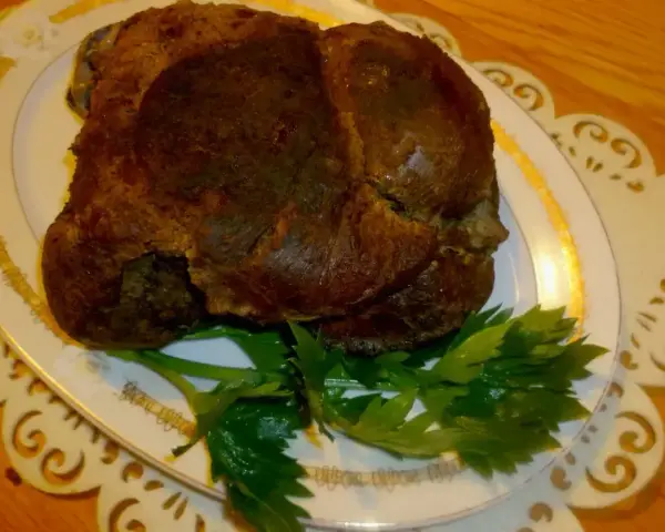 Apetyczna dziczyzna, pieczona do perfekcji, podana na eleganckim talerzu z gałązką natki pietruszki.