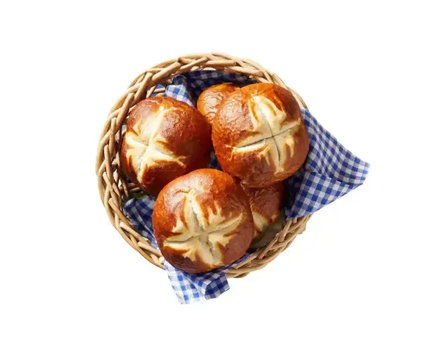 Koszyk z kilkoma bułkami bawarskimi, ułożonymi na niebiesko-białej kratkowanej ściereczce.