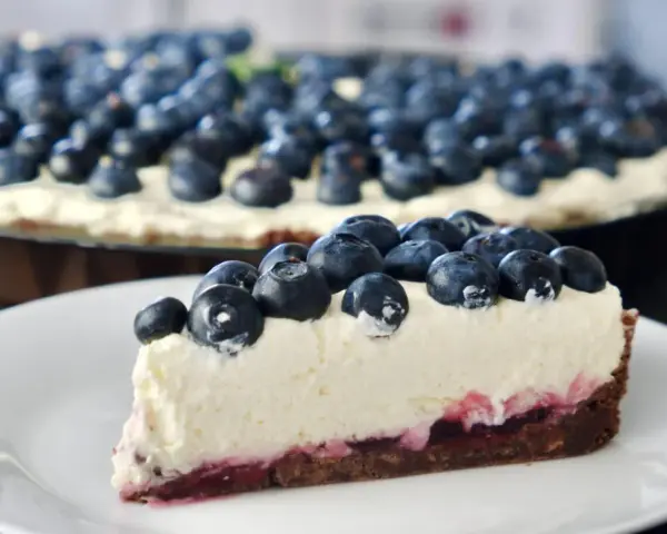 Pyszne ciasto z serkiem mascarpone pieczone, obficie udekorowane świeżymi borówkami. Idealne na deser.