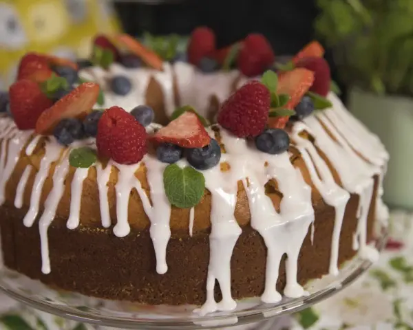Babka cytrynowa na oleju Ewy Wachowicz, udekorowana świeżymi owocami i lukrem.