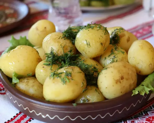 Młode ziemniaki z koperkiem, podane w glinianej misie. Czy ziemniaki tuczą? Zależy jak je przygotujesz!