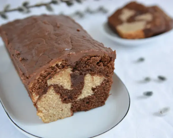 Wilgotna babka marmurkowa na oleju, z czekoladową polewą, prezentuje się apetycznie.