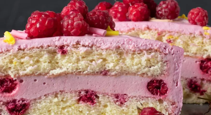 Pyszny tort z warstwami biszkoptu, przełożony kremem malinowym z mascarpone i świeżymi malinami.