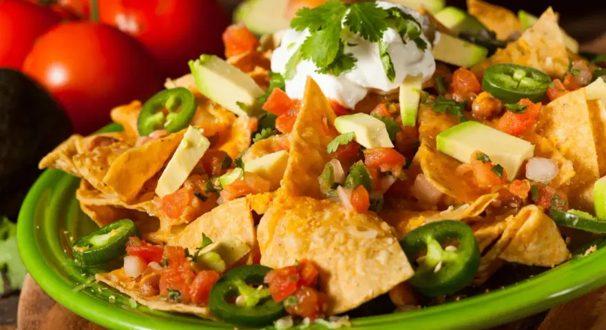 Nachos z serem, awokado, pomidorami i jalapeño. Idealna przyprawa meksykańska na imprezę.