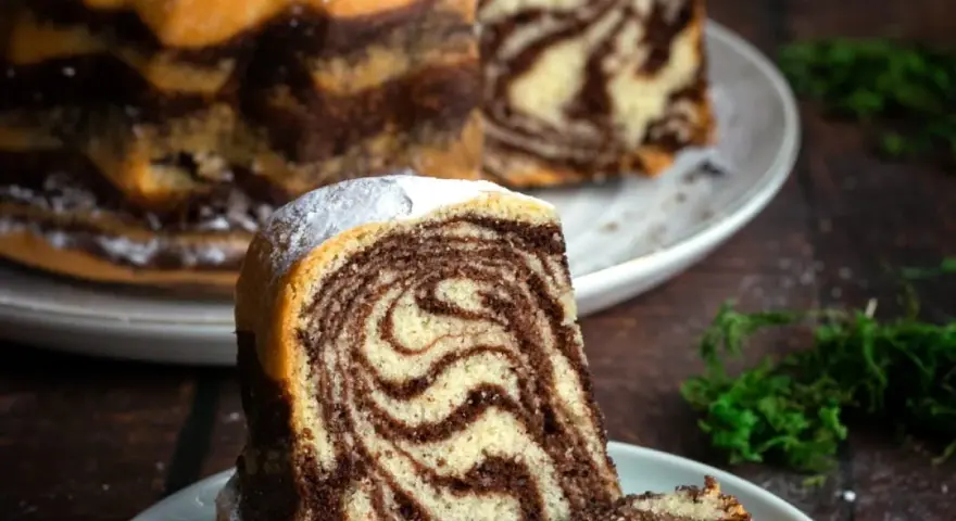 Wilgotne ciasto zebra z pięknymi wzorami, posypane cukrem pudrem. Idealne na deser.