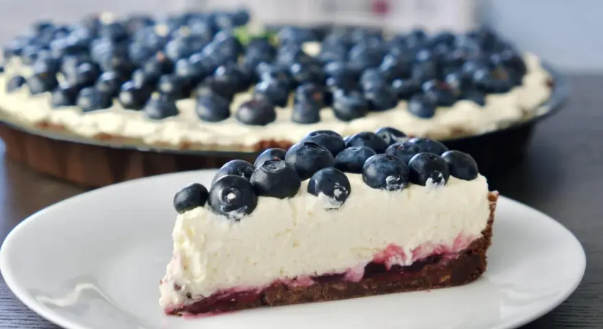 Pyszne ciasto z serkiem mascarpone pieczone, obficie udekorowane świeżymi borówkami. Idealne na deser.