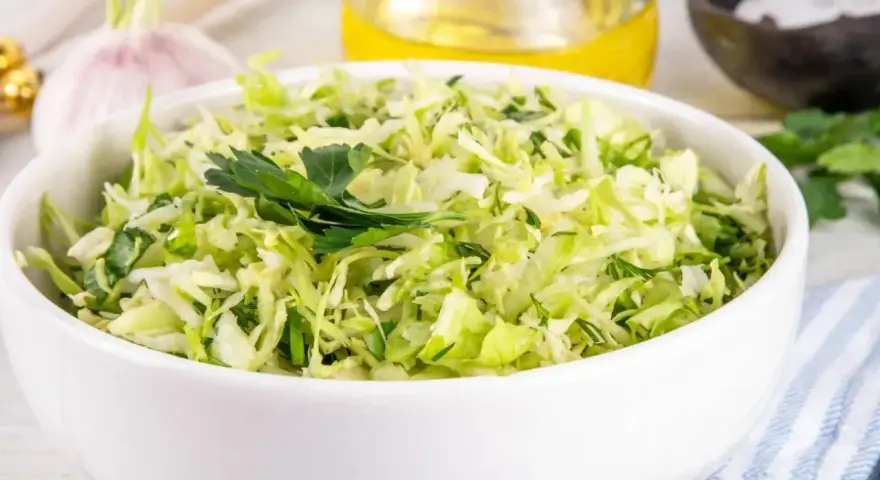 Sałatka z kapusty z czosnkiem i ziołami, idealna jako dodatek do obiadu. Cząber do czego? Do takich właśnie świeżych, aromatycznych sałatek!