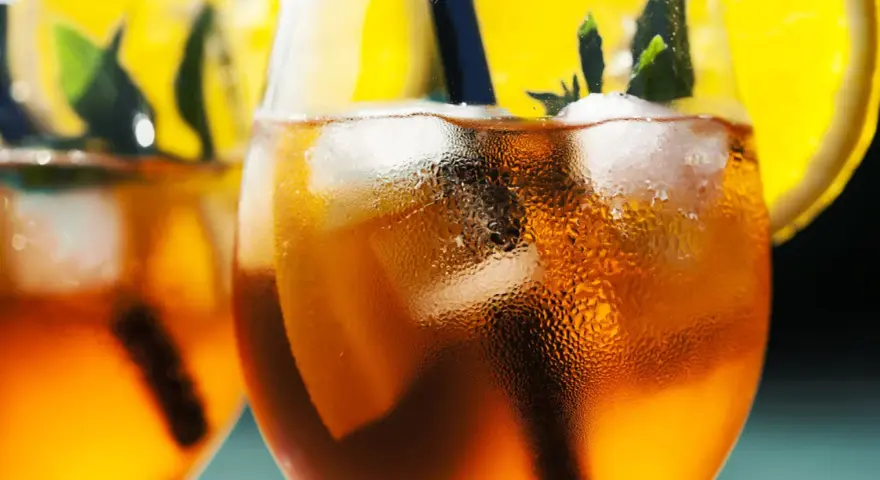 Orzeźwiający aperol bezalkoholowy z lodem, plasterkiem pomarańczy i miętą. Idealny na upalne dni.