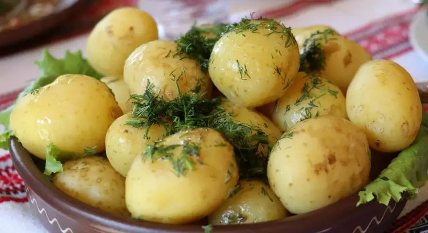 Młode ziemniaki z koperkiem, podane w glinianej misie. Czy ziemniaki tuczą? Zależy jak je przygotujesz!