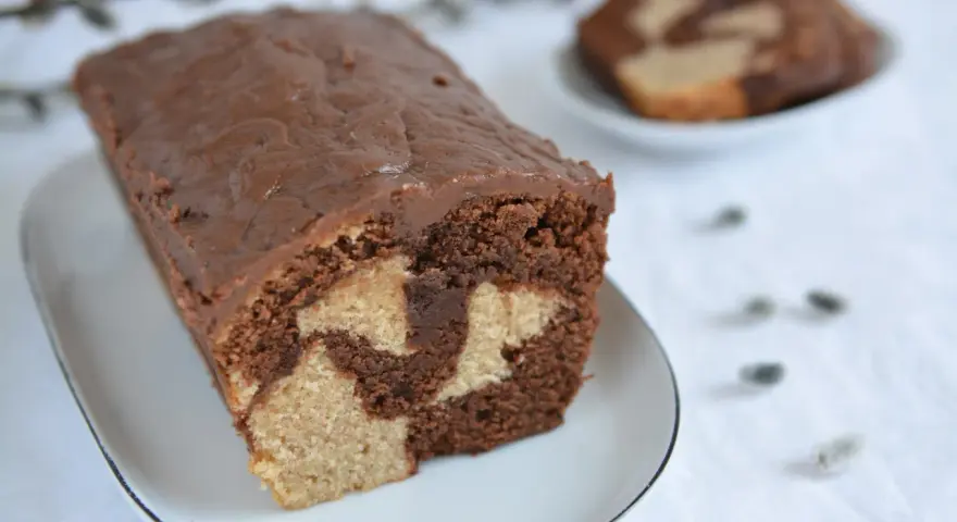 Wilgotna babka marmurkowa na oleju, z czekoladową polewą, prezentuje się apetycznie.