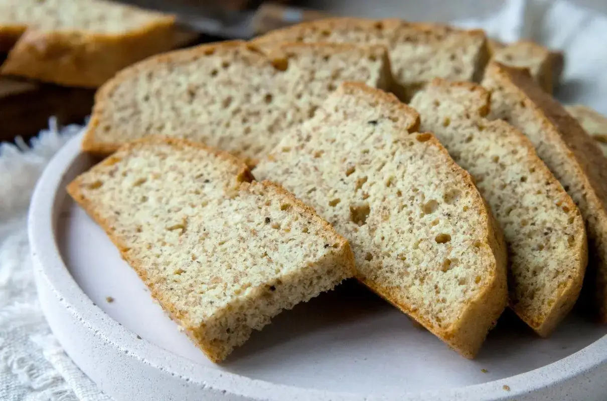 Pokrojony na kromki chleb keto, lekko zarumieniony, z widocznymi drobnymi ziarnami. Idealny na niskowęglowodanową dietę.