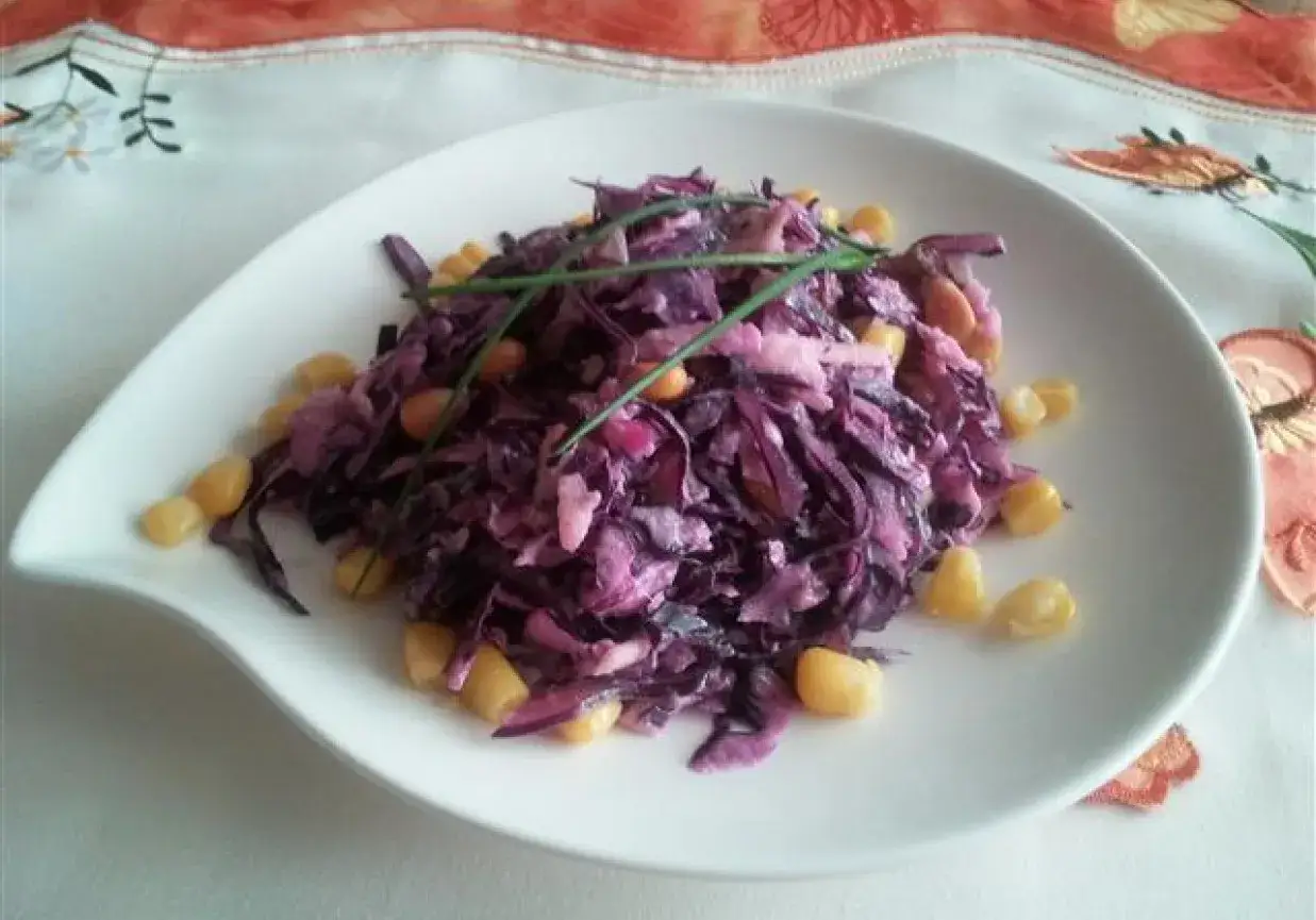 Pyszna surówka z czerwonej kapusty z kukurydzą, udekorowana szczypiorkiem. Wygląda jak surówka z czerwonej kapusty jak w restauracji.