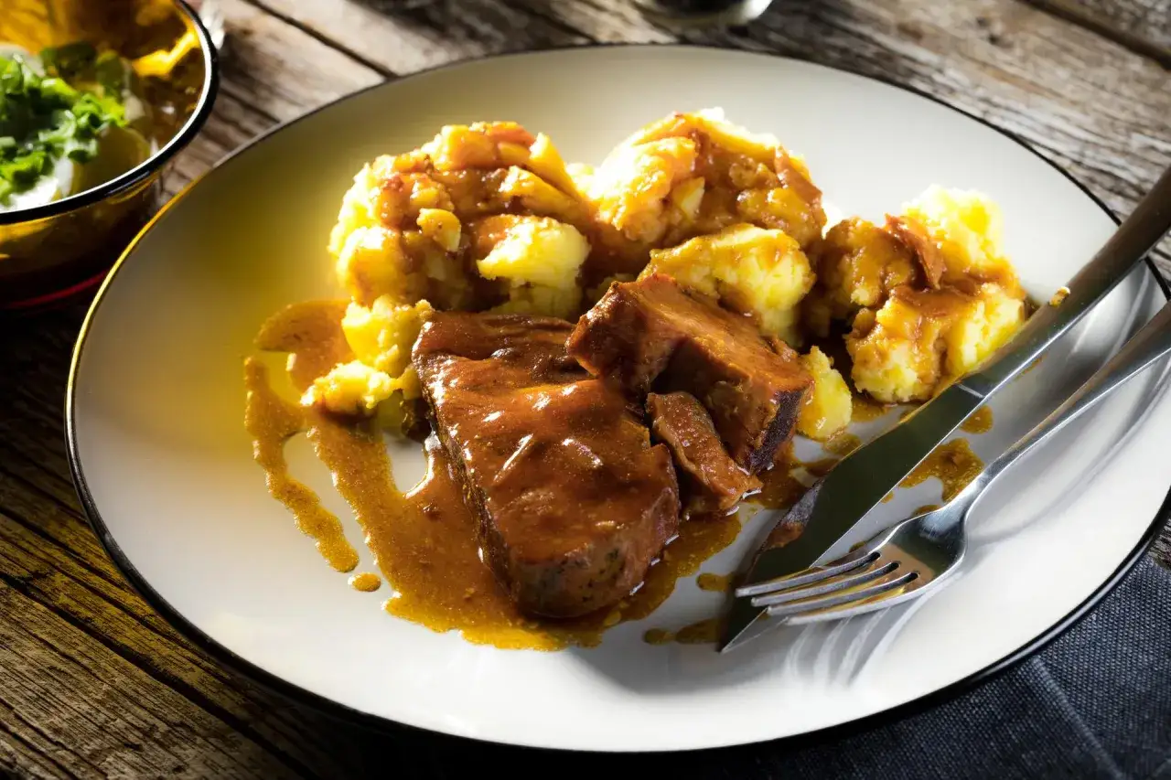 Karkówka po zbójnicku w plastrach, podana z ziemniakami i sosem. Pyszne danie, które zadowoli każdego miłośnika mięsa.