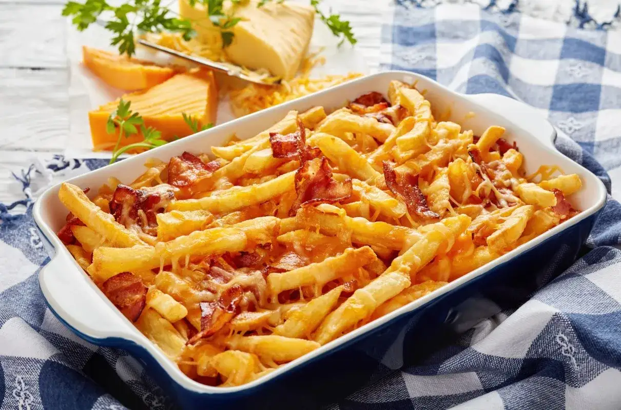 Chrupiące frytki z serem i bekonem w naczyniu, zapiekane do złocistości. Idealna przekąska dla każdego smakosza.