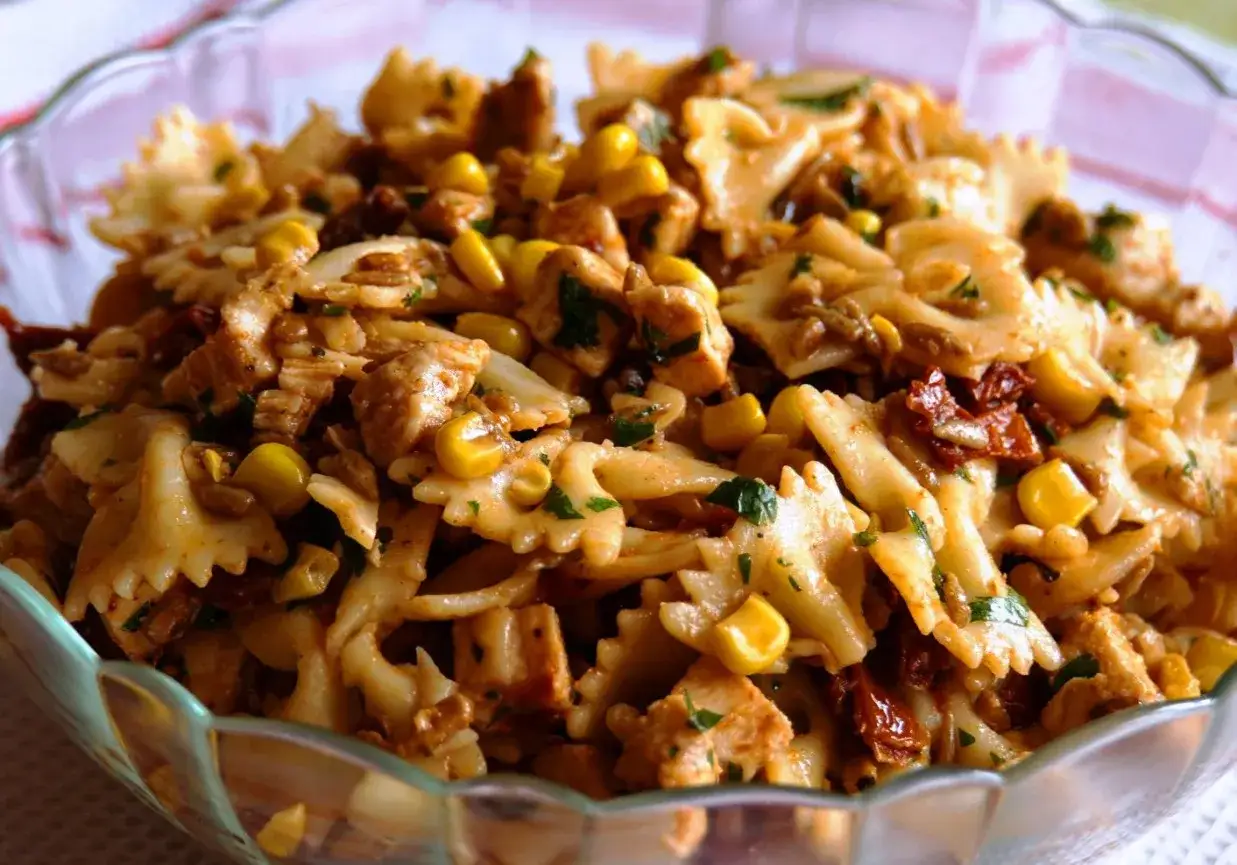 Najlepsza sałatka z kurczakiem na imprezę: makaron farfalle z kawałkami kurczaka, kukurydzą i suszonymi pomidorami w sosie.