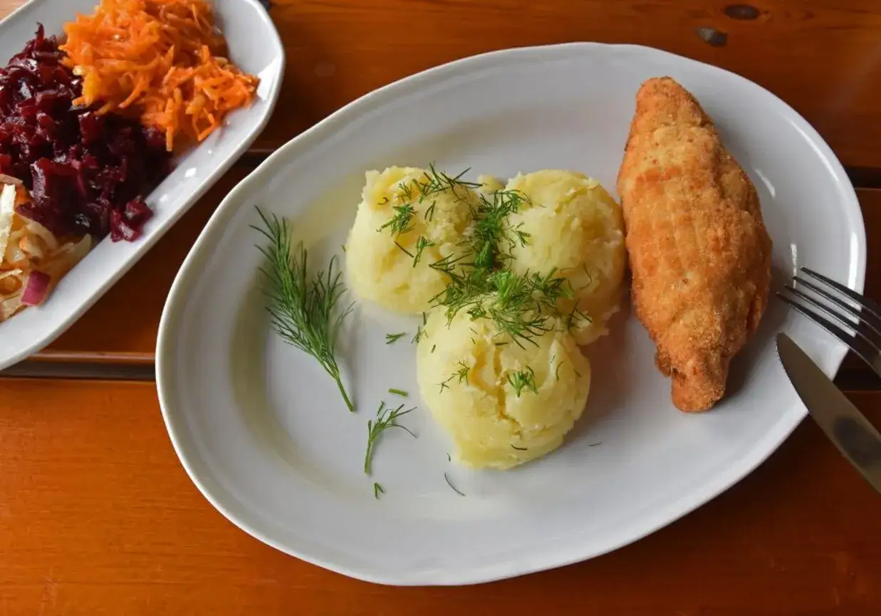 Chrupiący dewolaj z ziemniakami i koperkiem, obok surówka z buraków i marchewki.