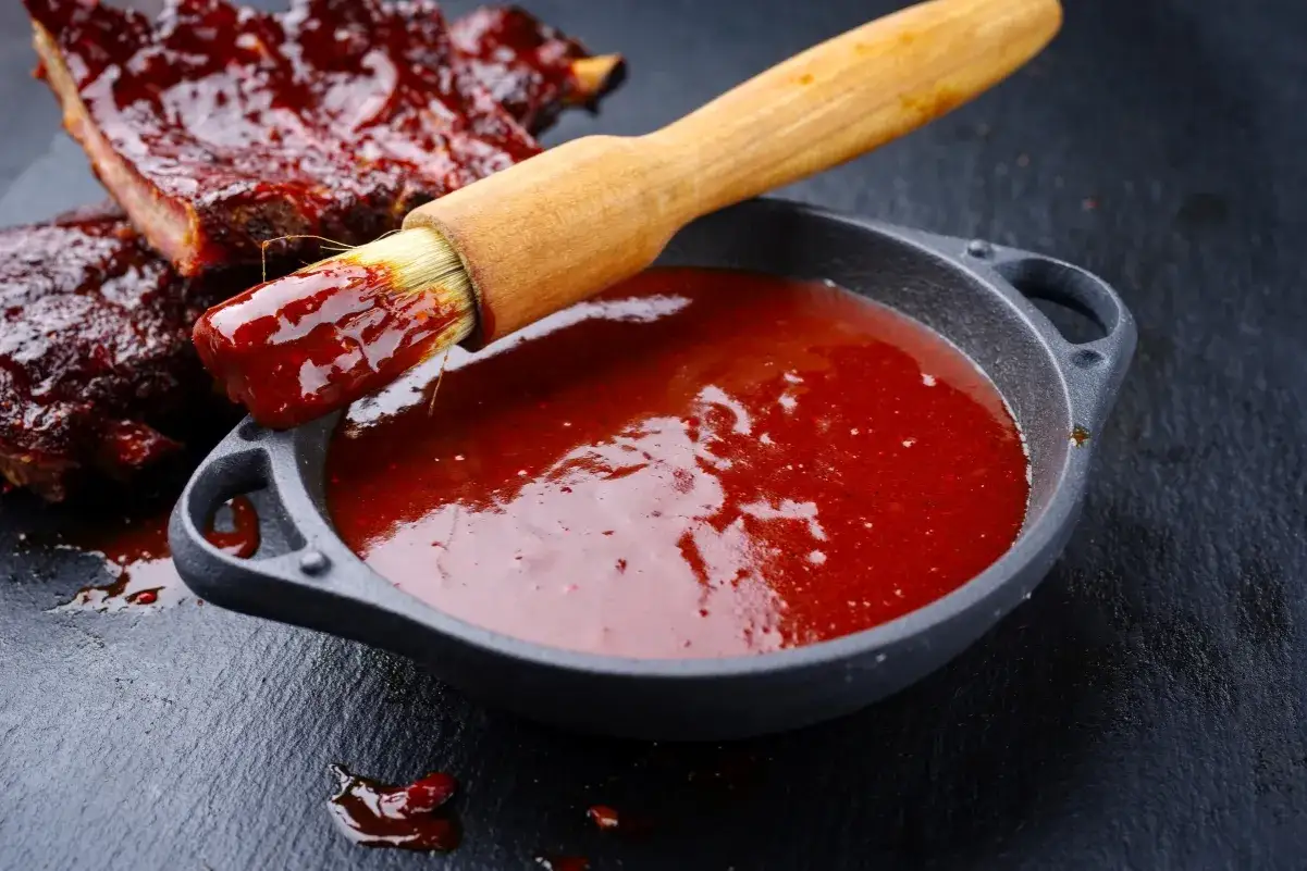 Pyszne żeberka w sosie barbecue, pędzelek zanurzony w sosie, idealny przepis na sos barbecue.