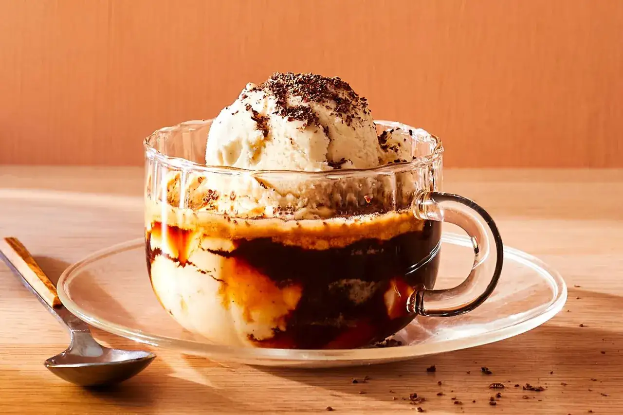 Pyszne affogato: dwie gałki lodów waniliowych w szklance, polane gorącym espresso, posypane startą czekoladą.