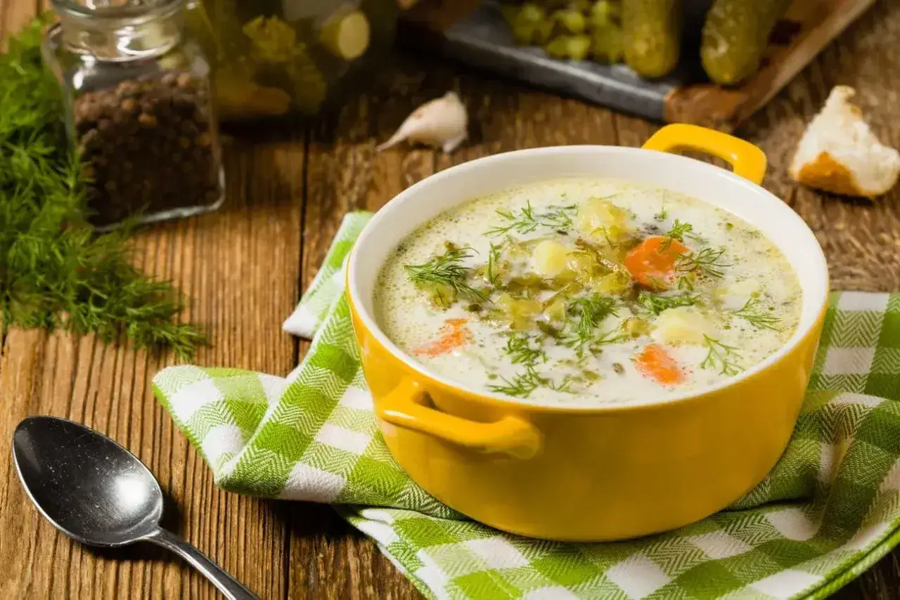 Zupa ogórkowa z koperkiem, ziemniakami i marchewką. Idealne jakie przyprawy do zupy ogórkowej? Koperek, pieprz i czosnek.